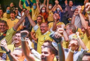 imagem colorida de Geraldo Alckmin comemorando o gol do Brasil com a camisa da Seleção Brasileira amarela - Metrópoles