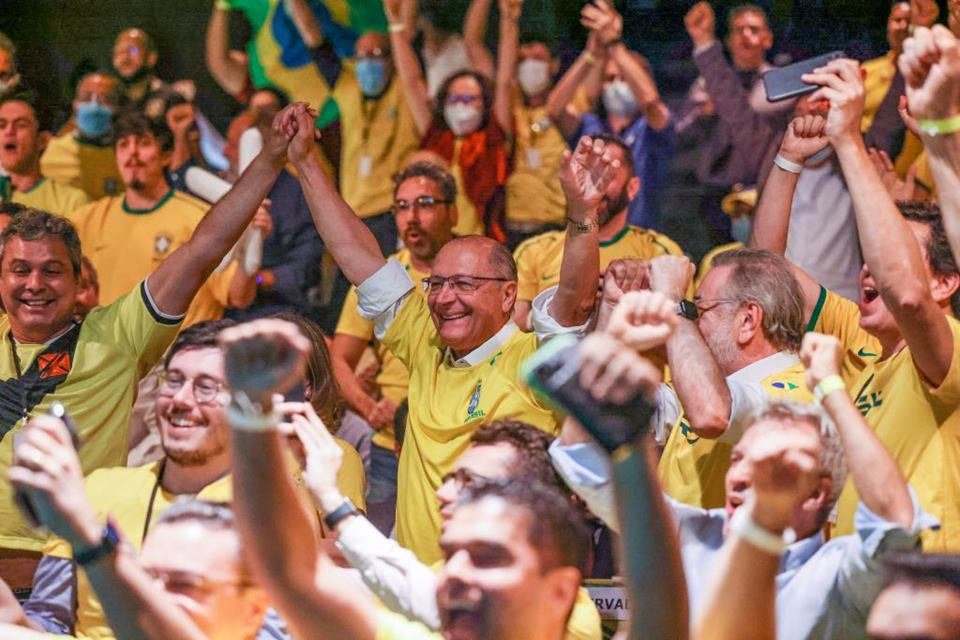 imagem colorida de Geraldo Alckmin comemorando o gol do Brasil com a camisa da Seleção Brasileira amarela - Metrópoles