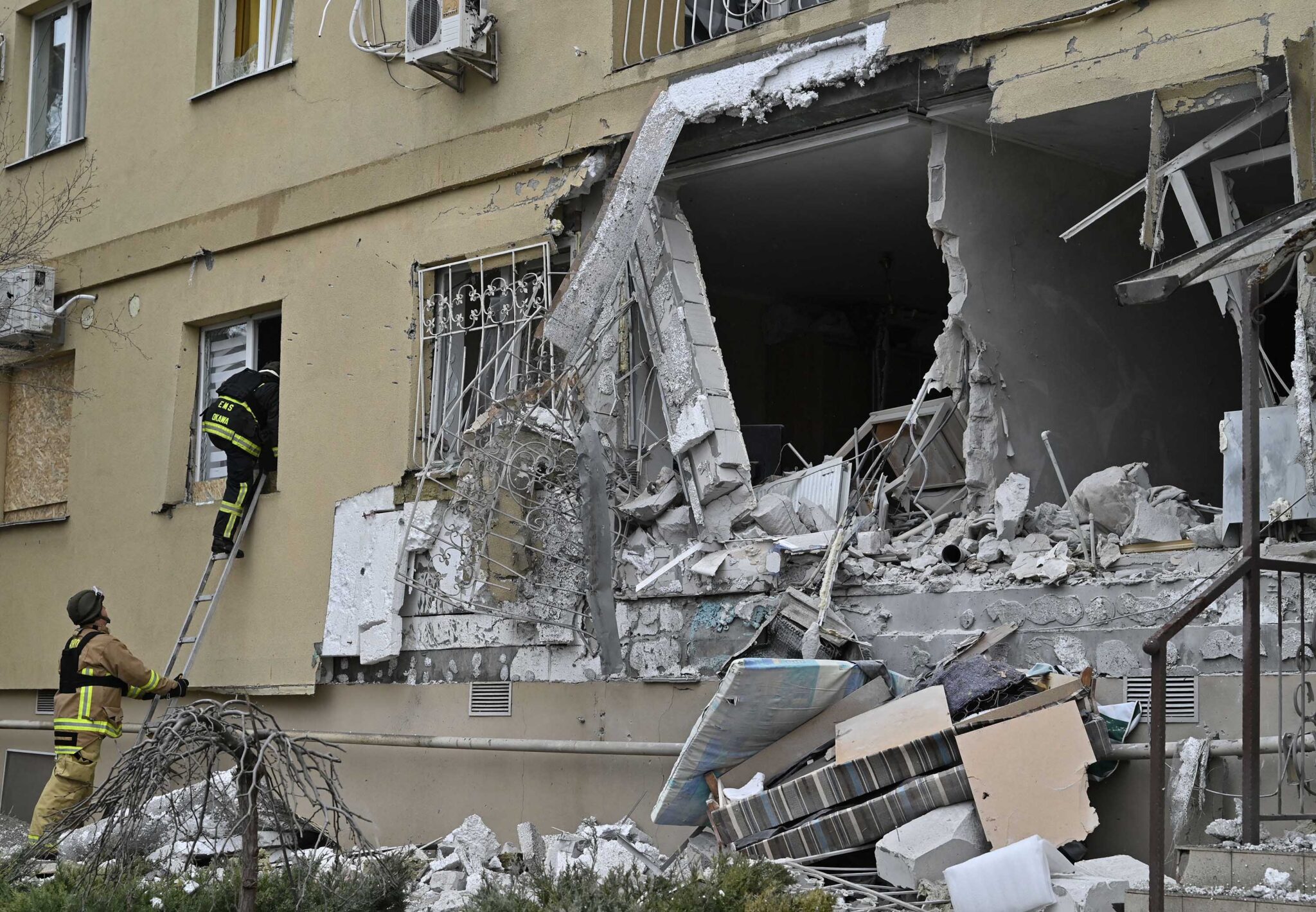 Equipes de emergência examinam um prédio residencial danificado após um bombardeio russo em Kherson, sul da Ucrânia, em 29 de janeiro.