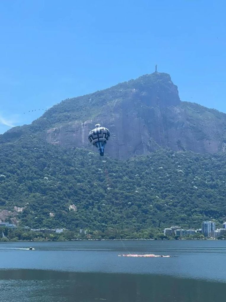 lagoa com morro atrás e balão voando - metrópoles